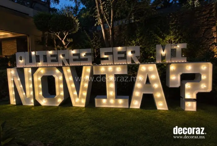 Letras gigantes iluminadas con la frase Quieres ser mi novia para propuesta romántica