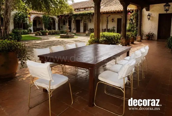 Mesa vintage caoba con sillas metálicas doradas y cojines color marfil para banquete elegante