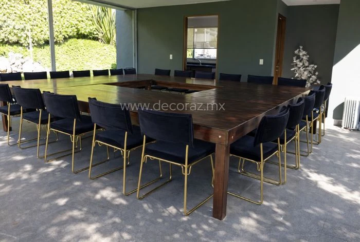 Mesa vintage caoba montada con sillas negras y doradas para evento elegante